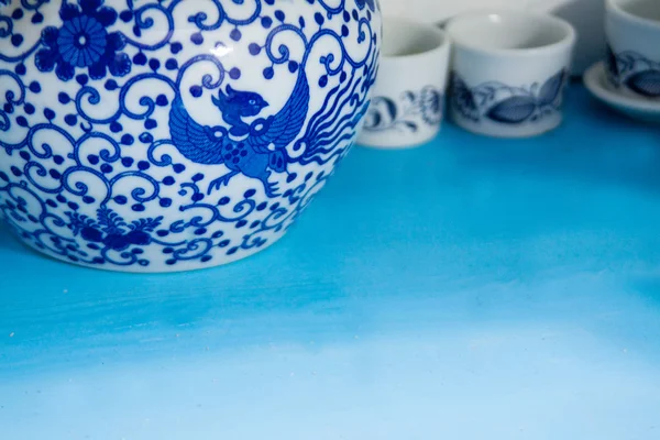 Utensílios de cozinha de cerâmica branca e azul na antiga prateleira de madeira azul — Fotografia de Stock