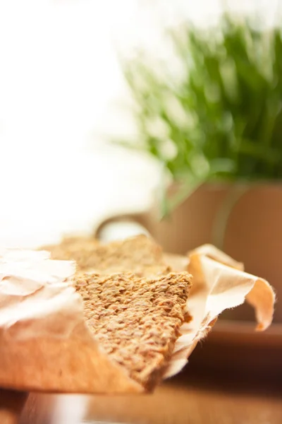 Tray with crispbreads and cup of grass — Stock Photo, Image