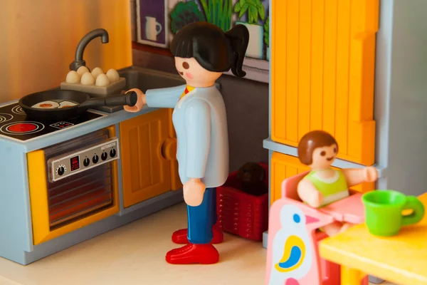 Des petits jouets en plastique. Maman se prépare à manger — Photo