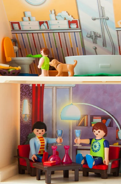 Casa de muñecas de plástico con una familia de muñecas dentro — Foto de Stock
