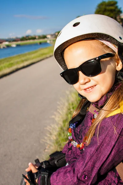 Kleines Mädchen trägt Rollschuhschutz im Freien — Stockfoto