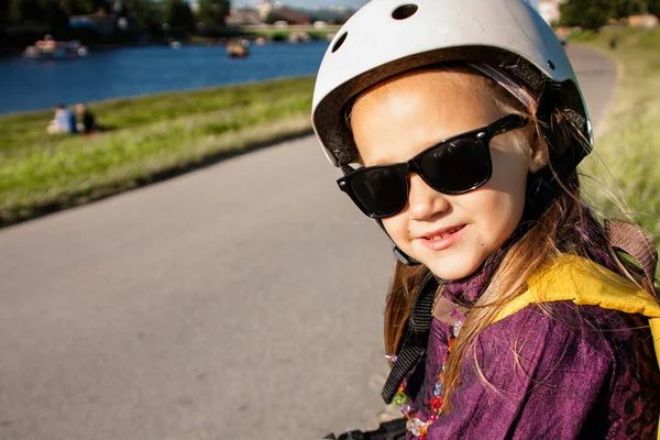 Linda niña usando en patines protección al aire libre — Foto de Stock