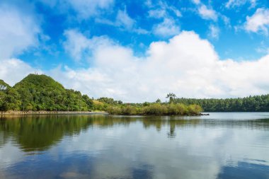 Göl manzarası ve bulutlu mavi gökyüzü.