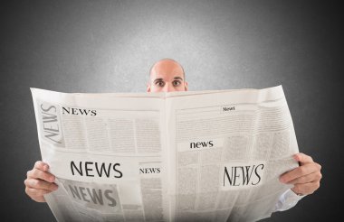 bir gazete okuyan adam