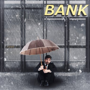bir banka önünde oturan işadamı