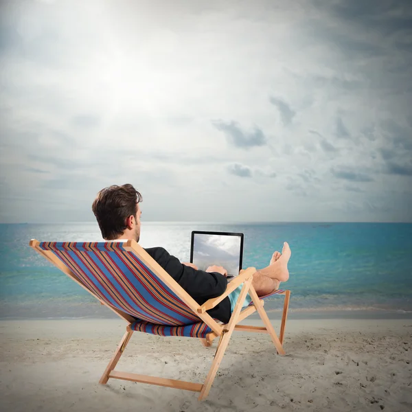 Zakenman met laptop op strand — Stockfoto