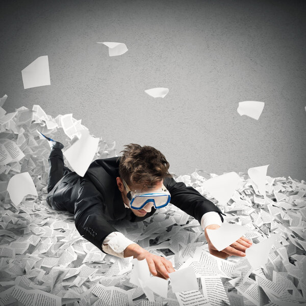 Бизнесмен плавает между простынями
