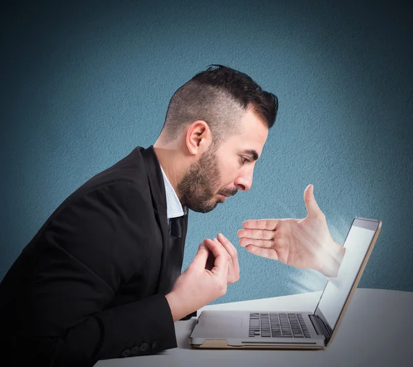Businessman with hand coming out from computer — Stock Photo, Image