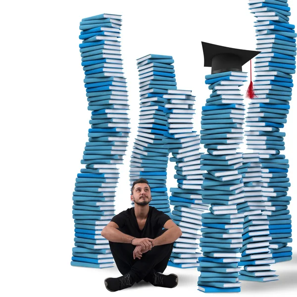Estudiante sentado entre pilas de libros — Foto de Stock