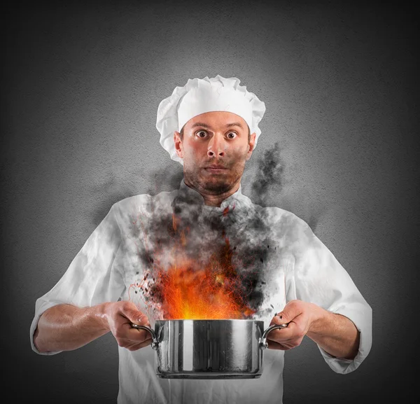 Chef segurando um pote com chamas — Fotografia de Stock