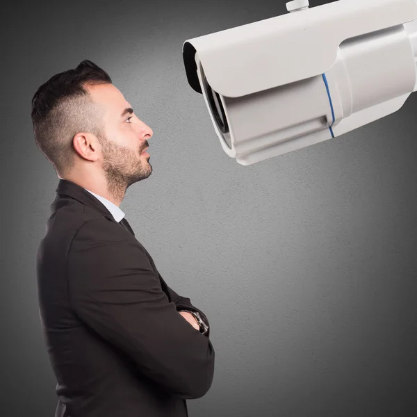 Empresário olha para uma câmera de vigilância — Fotografia de Stock