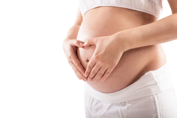 Zwangere vrouw maken een hart met handen — Stockfoto