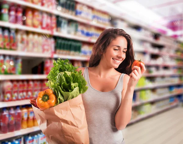 Žena v supermarketu kupovat zeleninu — Stock fotografie
