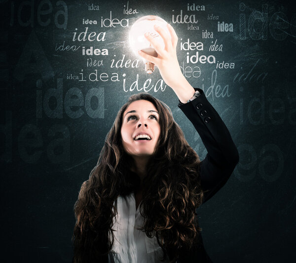 businesswoman looking at a light bulb