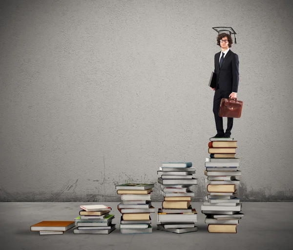 Man with graduation hat standing on scale — Stock Photo, Image