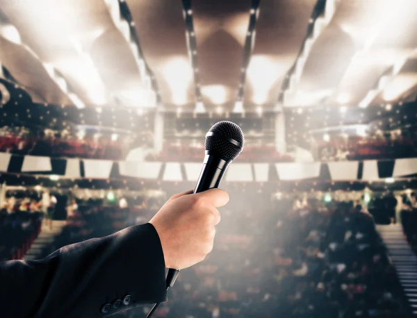 Mão com microfone em um teatro — Fotografia de Stock