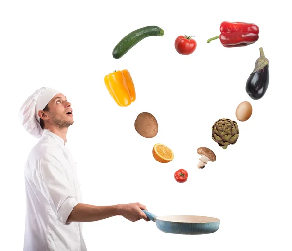 Kocken skapar ett hjärta hoppar på pan grönsaker — Stockfoto