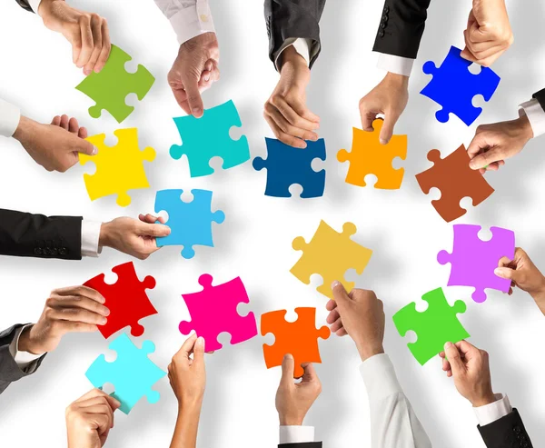 People holding the colorful puzzle pieces — Stock Photo, Image