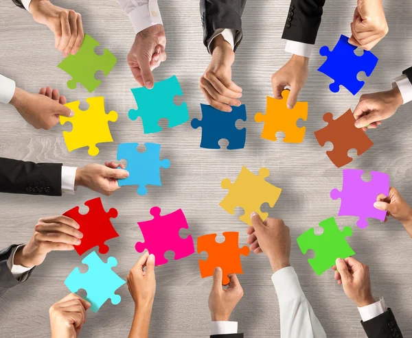 Persone che uniscono i pezzi puzzle colorati — Foto Stock