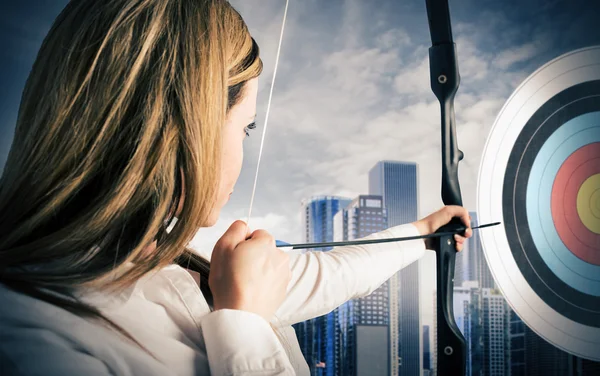 Mujer de negocios con arco y flecha apuntando — Foto de Stock