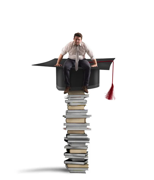 Affärsman som sitter på en hög med böcker — Stockfoto