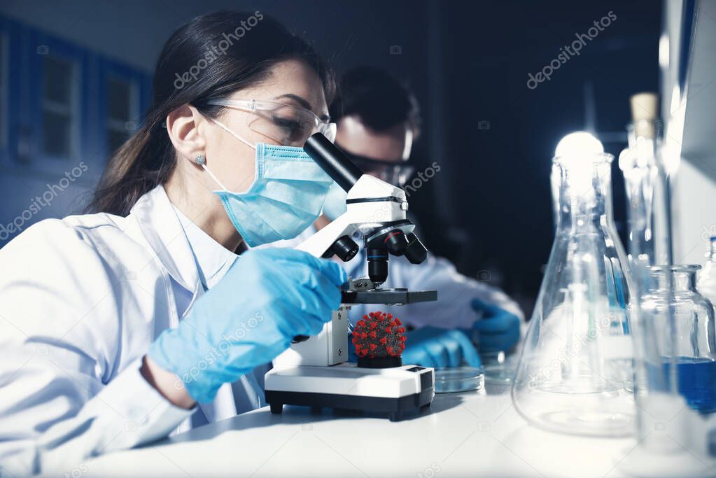Doctors in the laboratory analyze samples under a microscope. Pharmaceutical treatment concept