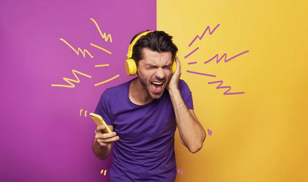 Ragazzo con auricolare giallo ascolta musica e balli. espressione emotiva ed energetica — Foto Stock