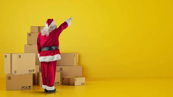 Санта Клаус перед картонными коробками, которые указывают на что-то в стене — стоковое фото