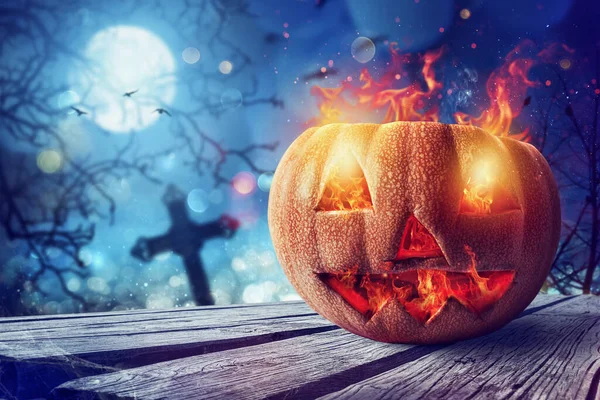 Smiling carved pumpkin of halloween with fire in a cemetery — Stock Photo, Image