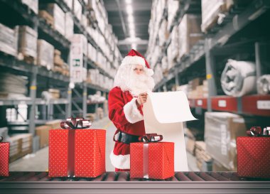 Noel Baba bir depoda Noel hediyesi siparişleriyle meşgul.