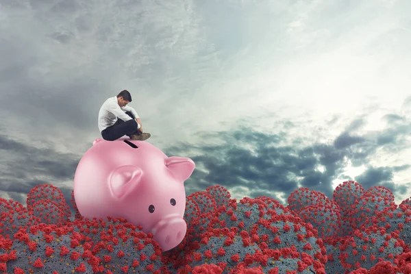 Business man in financial trouble due to coronavirus sails on piggy bank — Stock Photo, Image