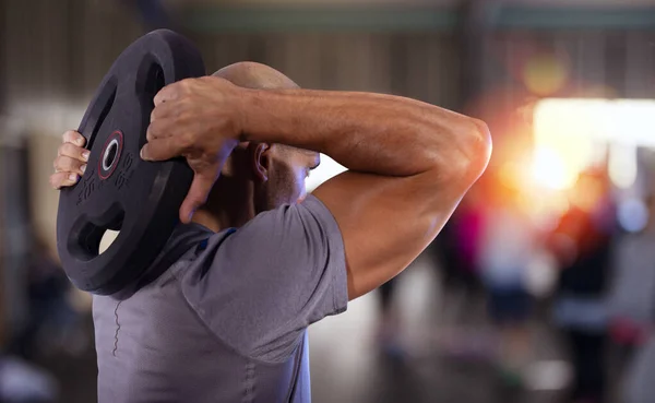 Spor salonunda kasları çalıştıran atletik bir adam. — Stok fotoğraf