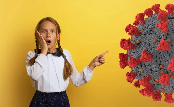 Estudiante joven con expresión conmocionada e indica bacterias covid-19. Fondo amarillo. —  Fotos de Stock