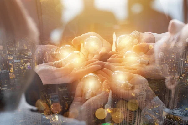 Trabalho em equipe e conceito de brainstorming com empresários que compartilham uma ideia com uma lâmpada. Conceito de inicialização — Fotografia de Stock