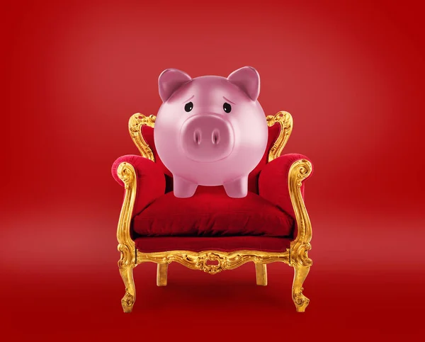 Comfortable red and golden armchair with a piggybank. Concept as premier savings service — Stock Photo, Image