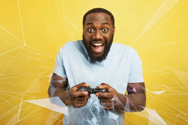 Happy man speelt met een videogame op gele achtergrond — Stockfoto