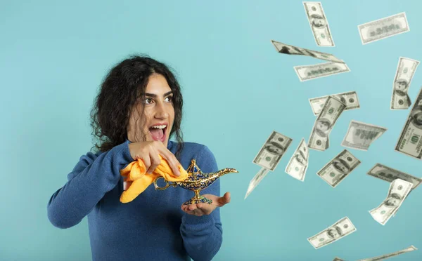 Woman is happy becaouse she founds lamp of aladdin and asked for money. Cyan background — Stock Photo, Image