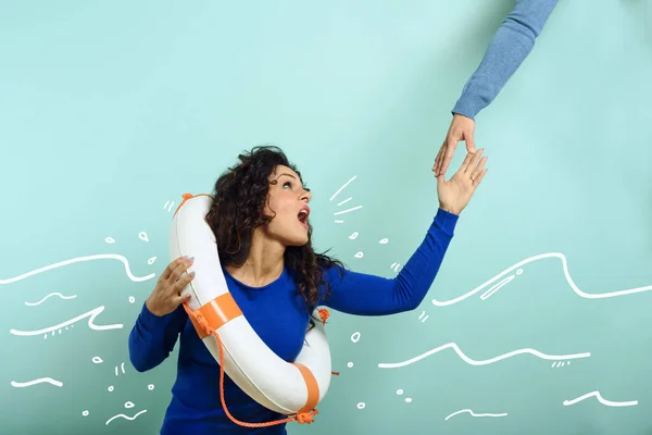 Vrouw is aan het verdrinken en vraagt hulp met een bericht van een papieren blad. Cyaan achtergrond — Stockfoto