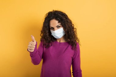 Kız covid 19 koronavirüsün yenilmesi konusunda iyimser. sarı arkaplan.