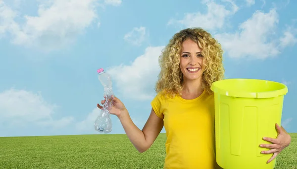 Donna è pronta a mettere una bottiglia di plastica nel bidone della spazzatura. — Foto Stock