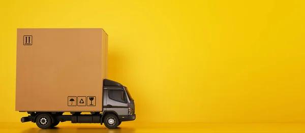 Grande scatola di cartone pacchetto su un camion grigio pronto per essere consegnato su sfondo giallo — Foto Stock