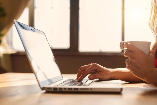 Femme surfe sur Internet avec son ordinateur portable. Elle travaille à la maison comme travailleuse intelligente — Photo