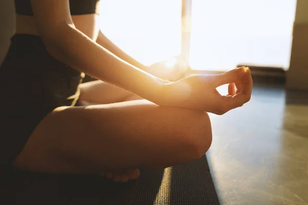 Chica joven relajándose en posición de yoga delante de una ventana brillante —  Fotos de Stock