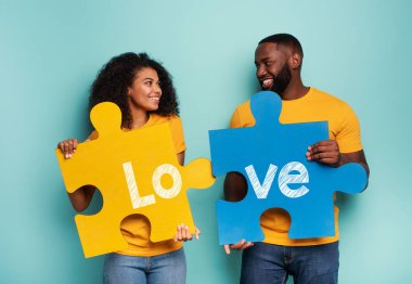 Açık mavi arka planda bulmacaları olan bir çift. Entegrasyon, birlik, ilişki ve ortaklık kavramı