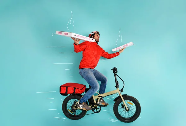 Dostawca biegnie szybko z rowerem elektrycznym, aby dostarczyć pizzę — Zdjęcie stockowe