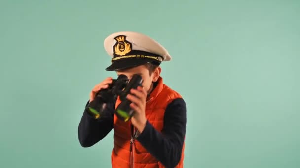 年轻的海员船长在海里看起来像个什么东西.青色背景 — 图库视频影像