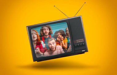 Sarı arka planda havada asılı duran klasik televizyon.