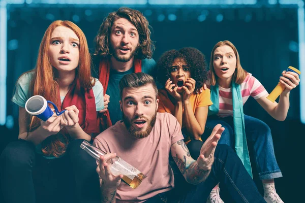 Meninos e meninas, atrás de uma tela, olham juntos um programa de TV em casa — Fotografia de Stock