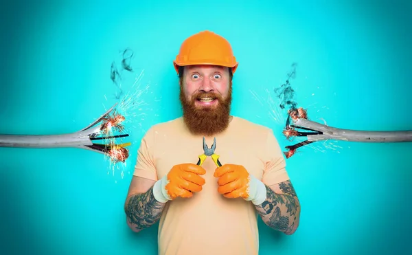 Incompetent worker electrician is unsure about his work. cyan background — Stock Photo, Image