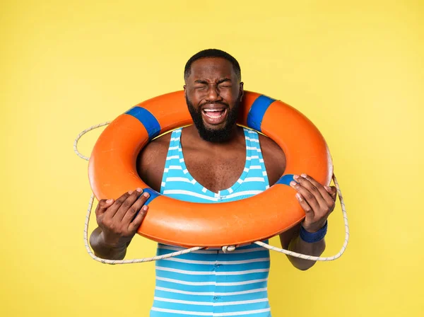 Can yeleği olan adam yüzmekten korkar. sarı arkaplan — Stok fotoğraf